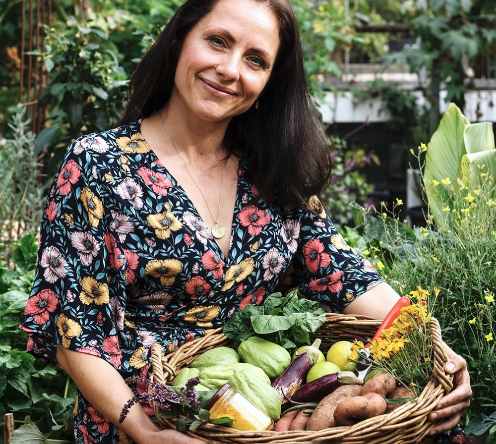 Katja Phegan out in the garden holding a basket full of fresh produce